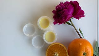Selbstgemachter Lippenbalsam, Orangen und eine Blume (Foto: SWR)