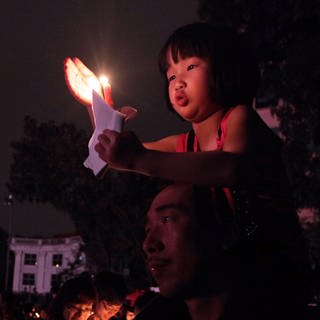 Ein Mädchen hält während der "Earth Hour" eine Kerze hoch. (Foto: dpa picture-alliance)