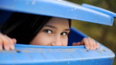 Mädchen schaut scherzhaft aus Mülltonne heraus (Foto: picture-alliance / Reportdienste, Frank May)